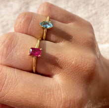 Load image into Gallery viewer, Classic solitaire design with a colorful touch. Choose one of our handpicked gemstones to create your own unique piece of fine jewelry. This shape is possible in a vertical or horizontal direction. Wear this one individually or witch, mix, match or stack this one with your other jewelry. The classic band is always a good idea but if you like a little twist but still a timeless piece, check out our rings with a twisted band! This contains one London Blue Topaz and a Ruby with a marquise cut gemstone.