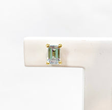 Load image into Gallery viewer, It's all in the details! Our studs are available in different colors. Choose your favorite colorful gemstone for that extra sparkle. Fine jewelry is fun and so are our studs. You can mix and match them with every other piece of our earring collection. Perfect as a first pair of earrings or small gift. Wear our studs individually or pared, it's up to you! Rectangle / Emerald Sky Blue Topaz earring studs.